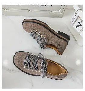 Detailansicht brauner Wildleder-Herrenschuhe im britischen Stil auf weißem Marmor