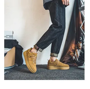 Khaki suède herensneakers gedragen met jeans in een lifestyle setting, detailweergave.