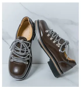 Detailansicht der dunkelbraunen glänzenden Herrenschuhe im britischen Stil mit dicken Sohlen.