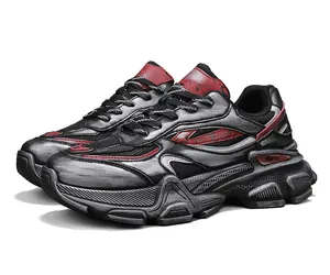 Dettaglio delle sneakers chunky grigie e rosse effetto invecchiato con texture metalliche