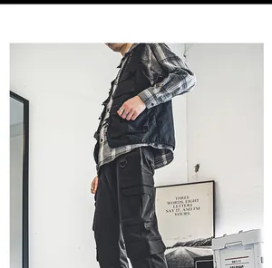 Detail van urban workwear-stijl voor heren met een zwart gilet met meerdere zakken.
