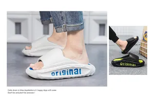 Close-up detail of white and black men's sporty slides with thick cushioned soles.