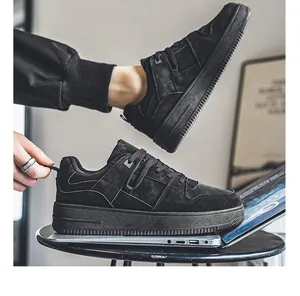 Gedetailleerd zijaanzicht van zwarte ademende suède sneakers op een laptopsteun