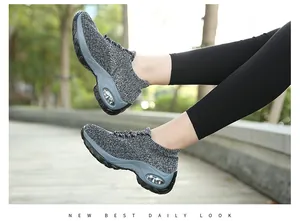 Vue détaillée de baskets de marche fly-knit gris à coussin d'air pour femme au parc
