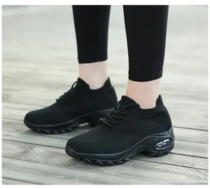 Gros plan de baskets noires en flyknit respirant avec semelle à coussin d'air sur bois