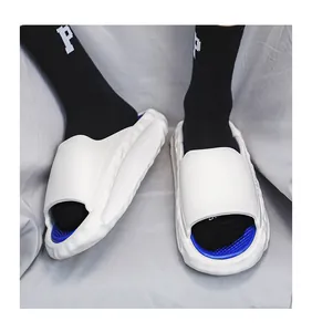 Detailed view of white soft sports slides with blue interior and wave-patterned thick soles