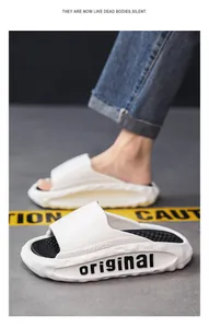 Close-up of white thick-soled sports slides with 'original' branding and soft texture.