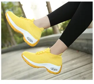 Vue latérale de baskets à coussin d'air flyknit jaunes respirantes pour femmes dehors