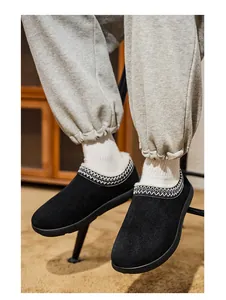 Gros plan de mocassins d'hiver en daim noir avec doublure en peluche et broderie