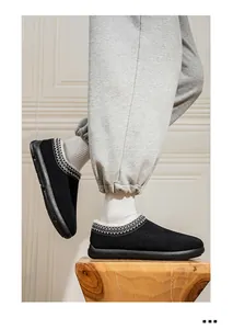 Gros plan de mocassins d'hiver en daim noir avec doublure en fourrure et motif ethnique.