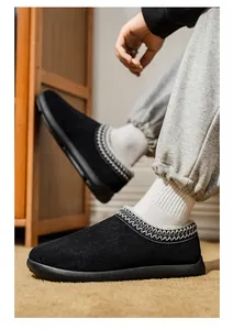 Gros plan de mocassins d'hiver en daim noir avec garniture tissée ethnique aux pieds