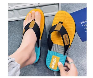 Dettaglio di infradito da uomo colorate con suole testurizzate gialle, grigie e blu.