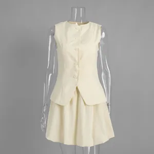 Front detail shot of pale yellow sleeveless vest and matching flared mini skirt set
