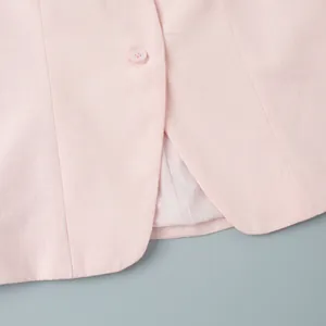 Close-up of pink linen-texture vest with single button and neat stitching finish