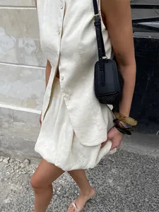 Detail view of ivory linen vest and bubble mini skirt set in street style
