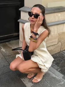 Detail view of a chic cream-colored vest and bud skirt suit worn by a model outdoors.