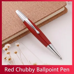 Gros plan d'un stylo bille en aluminium rouge avec des accents argentés sur un carnet