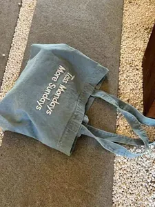 Close-up of retro blue canvas tote bag with 'Less Mondays More Sundays' slogan print