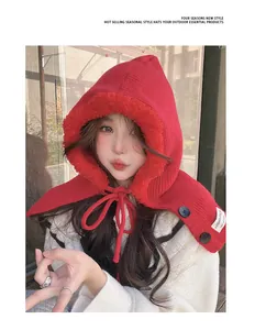 Close-up detail of a red knitted balaclava hood with plush lining and stylish button accents