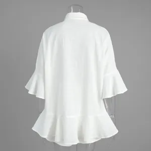 Détail arrière d'un chemisier blanc ample avec manches volantées et ourlet évasé chic.