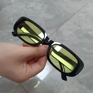 Detail view of retro square sunglasses featuring black frames and yellow tinted lenses