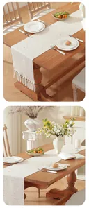 Vue détaillée d'un chemin de table américain crème avec pompons et fleurs roses