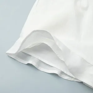 Vue détaillée de l'ourlet d'un short en lin blanc avec coutures et doublure soignées