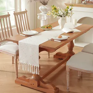 Chemin de table américain crème avec broderie rose et glands sur table en bois