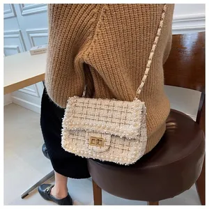 Close-up of elegant tweed crossbody bag with pearl trim and gold chain strap detail
