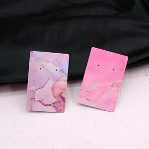 Detail view of thickened marble gold-foiled jewelry display cards for earrings and necklaces