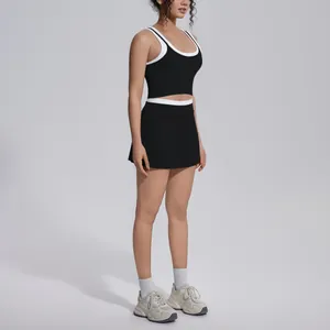Side view of woman wearing a black and white color-block ribbed yoga crop top and skirt set