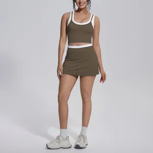 Full body view of a woman wearing an olive green ribbed sports top and skirt set