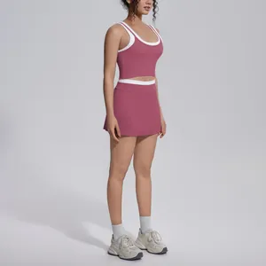 Two-piece pink and white athletic yoga set featuring a crop tank top and sports skirt