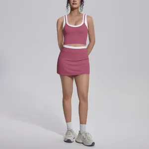 Detail view of a pink and white contrast yoga set with high-waist skirt and top.