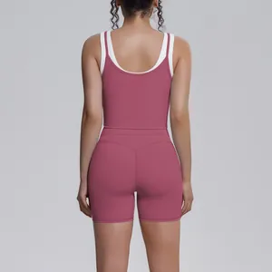 Back view of a pink ribbed yoga set with high-waisted biker shorts and contrast tank top.