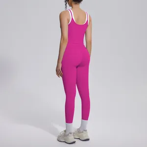 Back view of a woman in a pink and white ribbed yoga set with high-waist leggings.