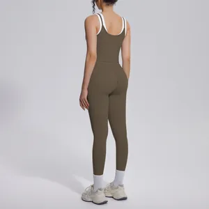 Back view of brown ribbed high-waisted yoga set with white contrasting straps details.