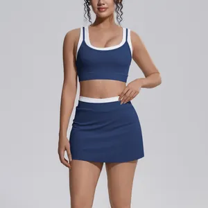 Detail shot of navy blue sports bra and mini skirt set with white contrast trim.