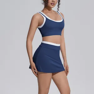 Detail of navy blue sports bra and high-waisted tennis skirt set with white ribbed trim.