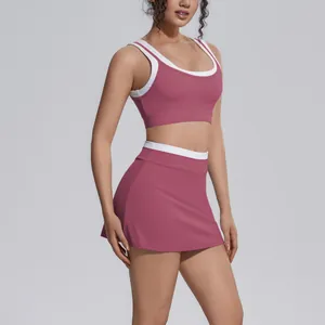 Detailed view of dusty rose yoga set with white ribbed trim on sports bra and skirt.