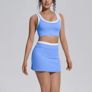 Close-up of blue sports bra and skirt set with white contrast trim on a fitness model