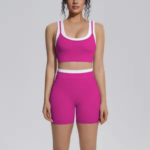 Two-piece pink and white ribbed yoga set with sports bra and high-waist fitness shorts