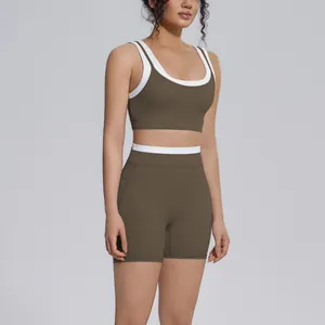 Model wearing a two-piece olive brown yoga set featuring elegant white contrast trim accents