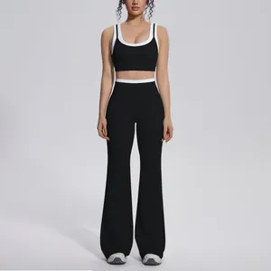 Full body view of a black and white color-blocked ribbed high-waisted yoga set on model