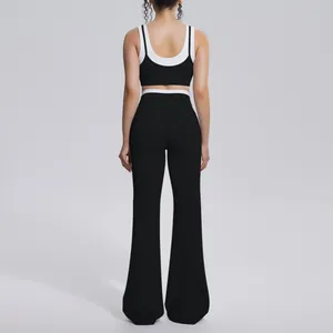 Back view of a premium black and white contrast yoga set featuring high waist flared pants