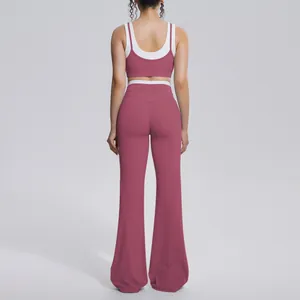 Back view of a dusty rose and white two-piece yoga set with flared leggings and sports bra.