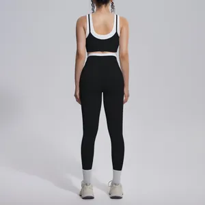 Back view of a black and white color-block ribbed high-waist yoga set for women