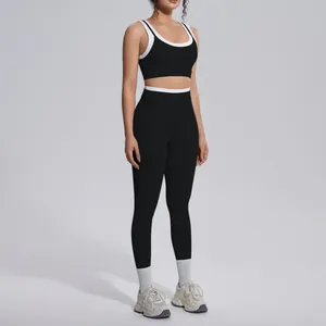Full body studio shot of a woman wearing a black and white contrast color yoga set
