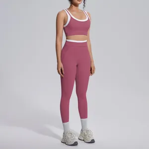 Full body model view of a rose pink yoga set with white trim in a studio setting