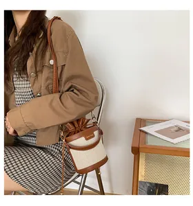 Detailed view of fashionable niche canvas bucket bag with brown leather trim and drawstring